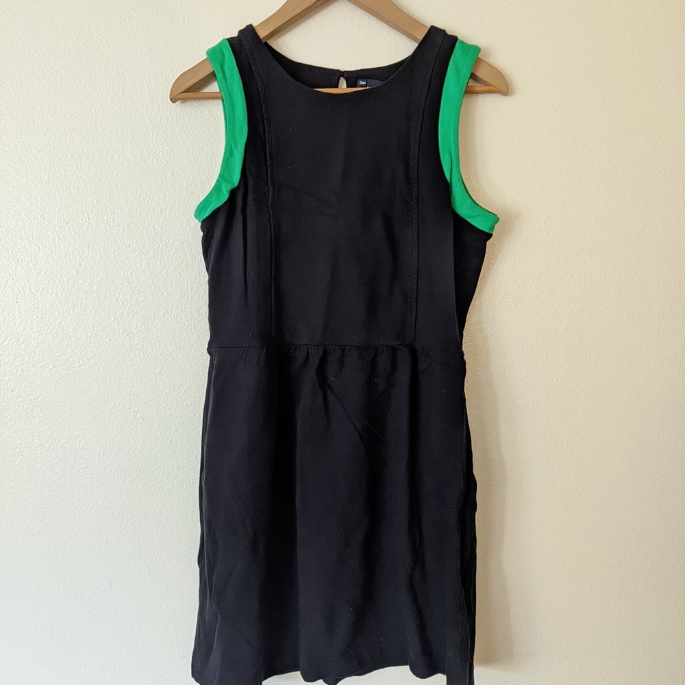 sleeveless black dress with green trimmed sleeves